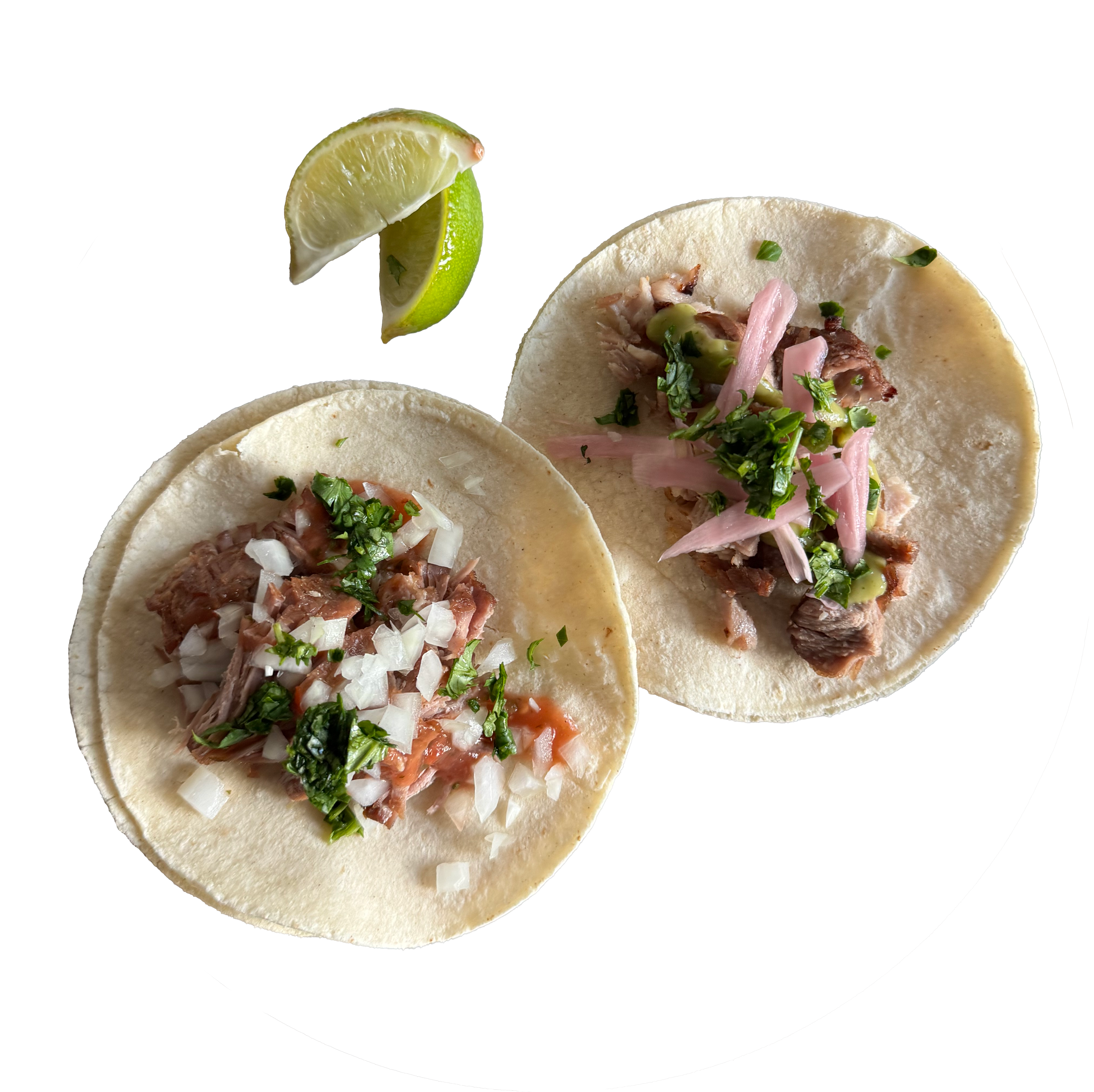 A photo of two carnitas tacos on small white corn tortillas with cilantro, onion, salsa, and lime.